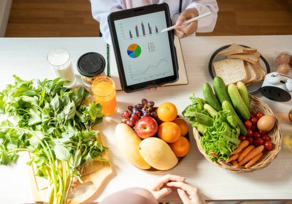 Detox concept. Afro woman patient of nutritionist drinking lemon water while doctor taking notes, close up